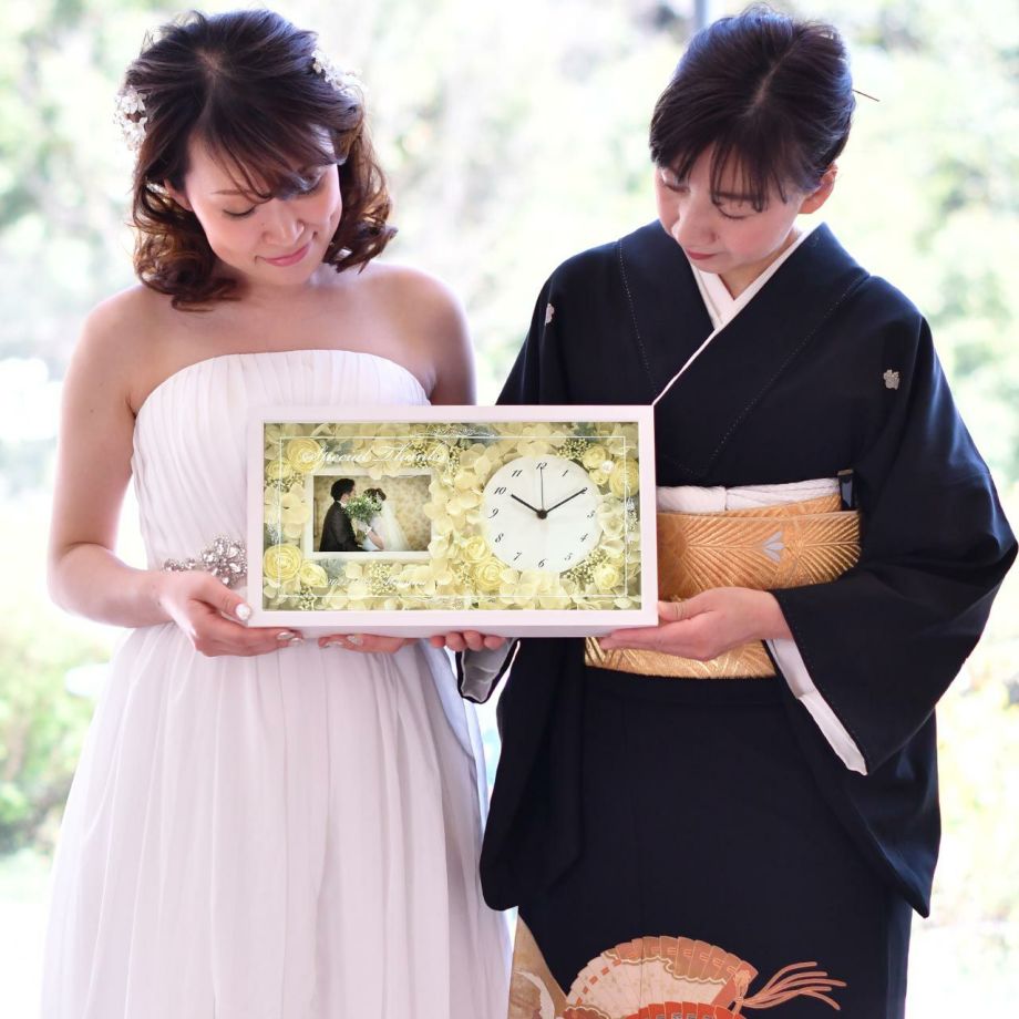 結婚式の両親贈呈品にフォトフレーム付きの花時計を贈る花嫁
