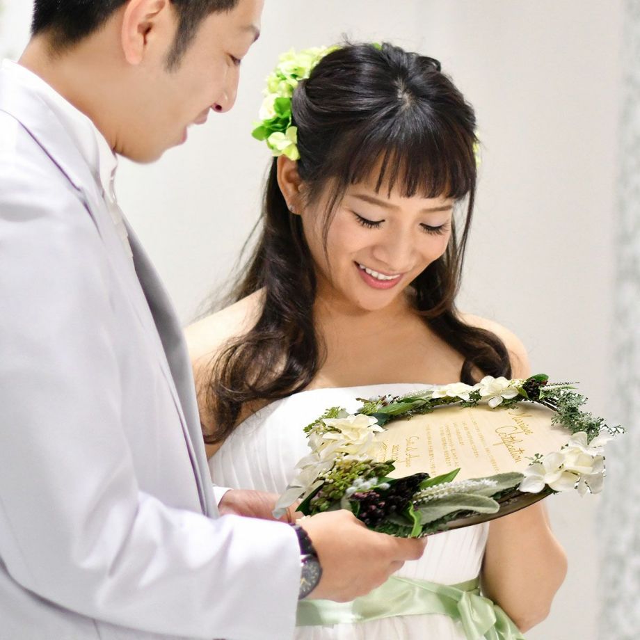 お花がアレンジされたリース型の結婚証明書で誓いのシーンも可愛く