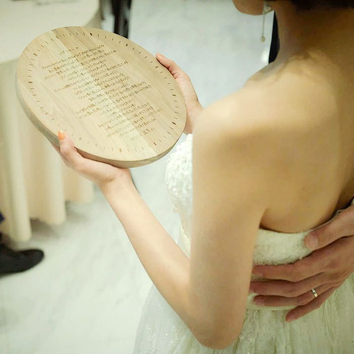 木製の花嫁の手紙に刻印された直筆のメッセージを読む花嫁