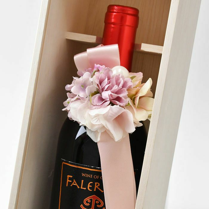 ワインにリボン付きのピンクの花飾りをつけている
