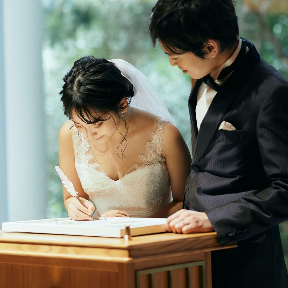 結婚証明書のサイン欄にサインする新郎新婦