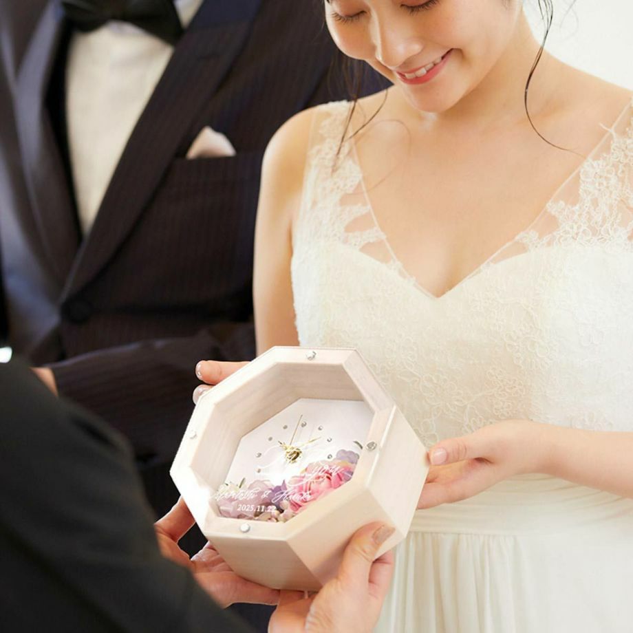 持ち運びに困らないサイズ感の八角花時計を渡す結婚式の贈呈シーン