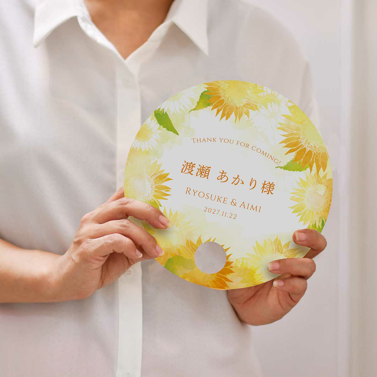 丸型うちわサンフラワーデザインを持っている