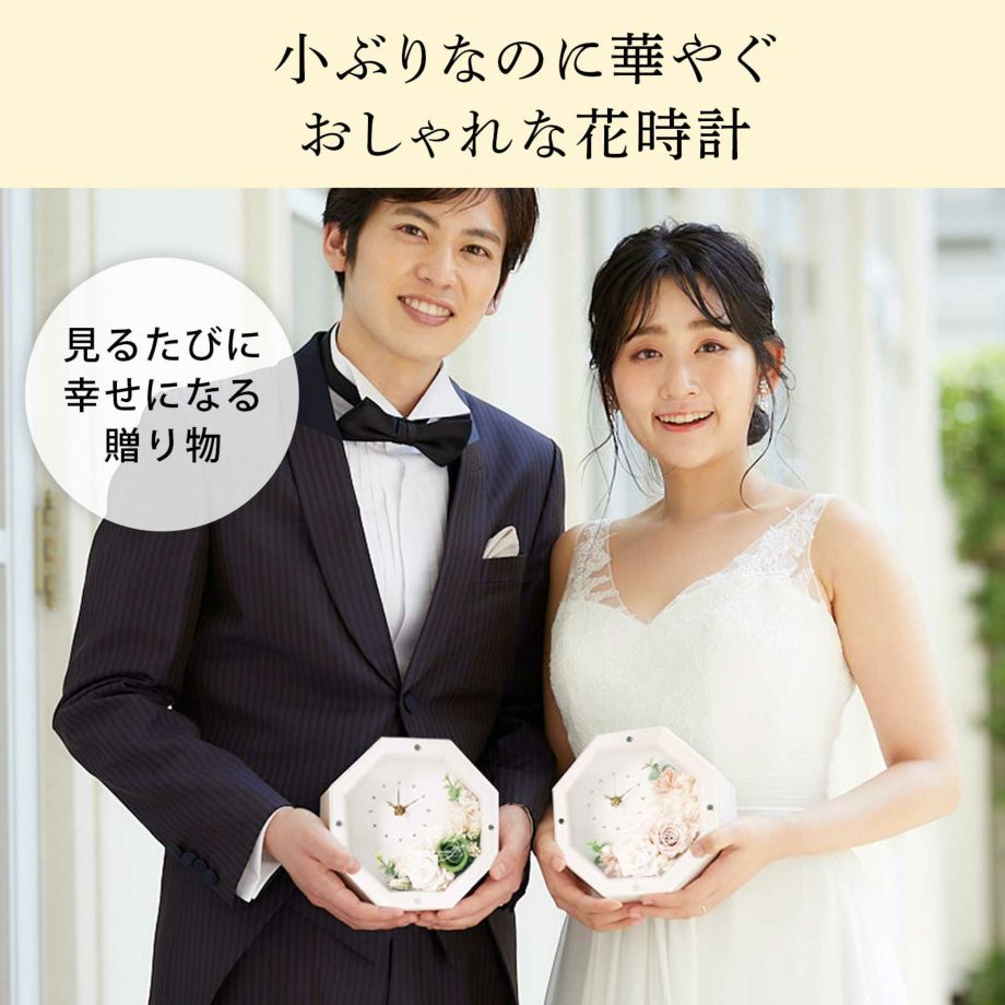 小ぶりなのにぱっと華やぐナチュラルで可愛らしいフラワーアレンジの花時計を持つ新郎新婦