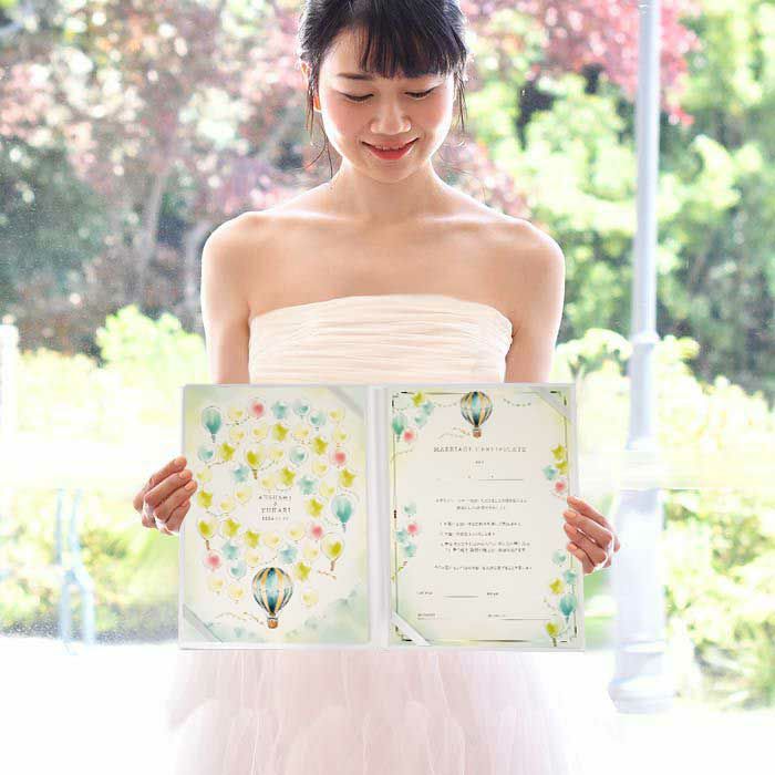 気球デザインの結婚証明書を持っている花嫁