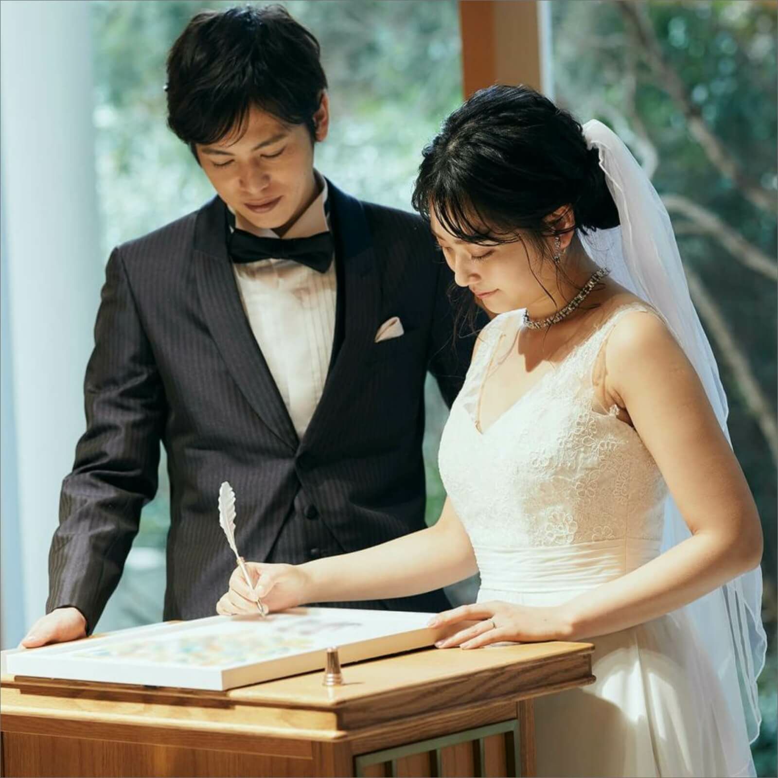 スタイルに合わせて選べるサイン欄の証明書にサインをする新郎新婦